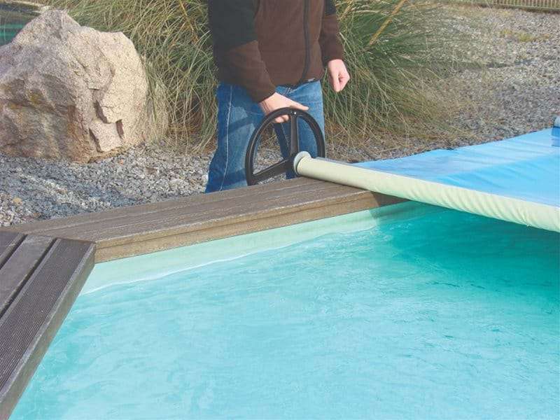 manual safety pool cover being used to cover a wooden pool.