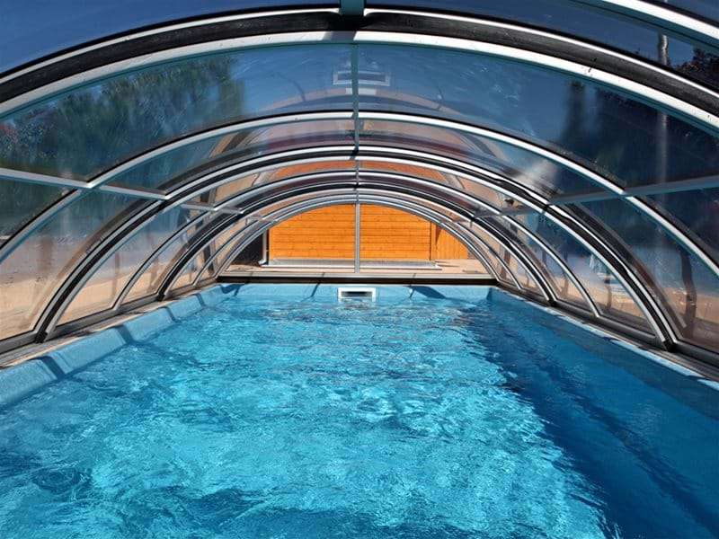inside view of sun or sky pool enclosure covering a one piece swimming pool.