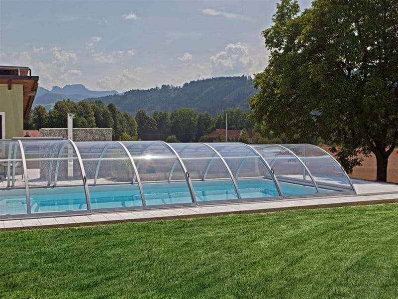 side view of sun or sky pool enclosure covering a one piece swimming pool.