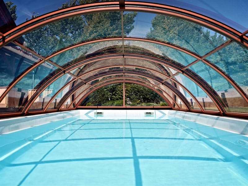inside view of sun or sky pool enclosure covering a one piece swimming pool.