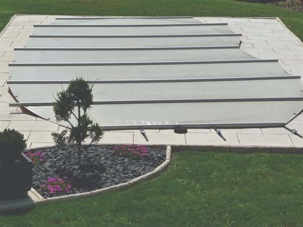 manual safety pool cover, covering a one piece swimming pool.